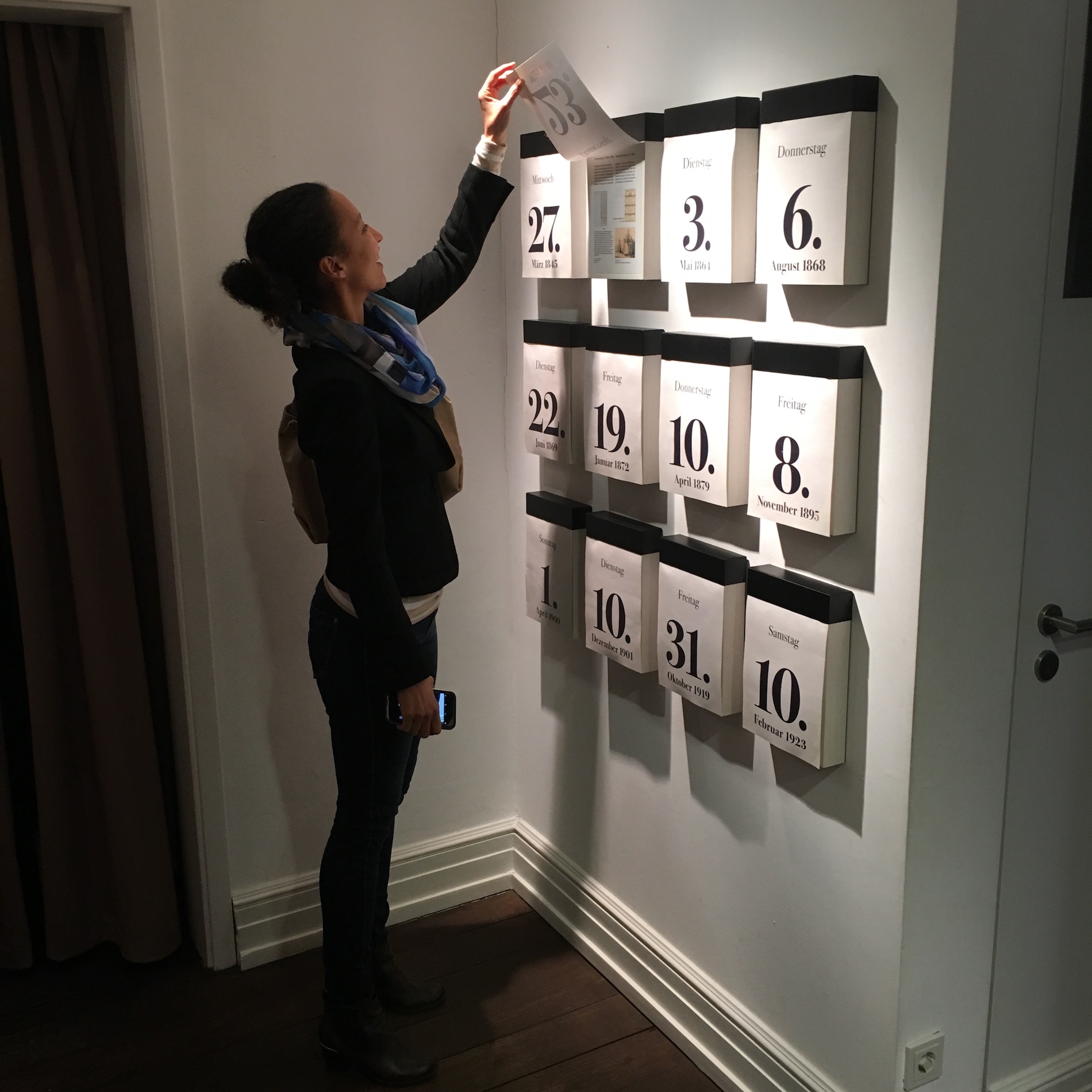 Eine Frau guckt sich Kalenderblätter im Röntgen Museum an