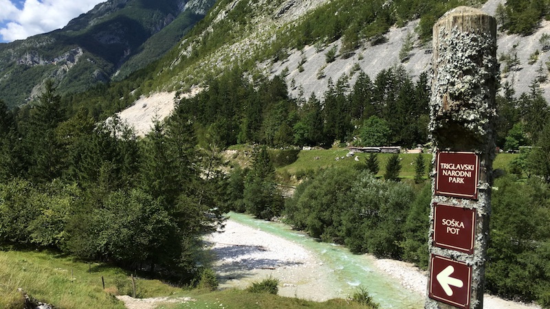 Ein Wegweiser vom Soca Weg Soska pot vor toller Alpenlandschaft